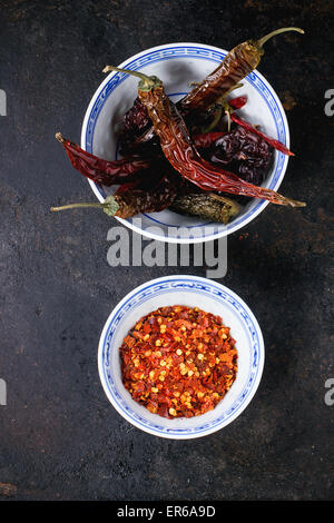 Assortiment de frene ensemble et paillettes de Red Hot Chili Peppers en bols de céramique sur fond noir Banque D'Images