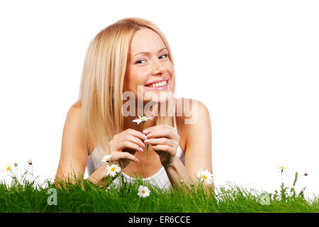 Happy young woman lying on grass avec fleurs de camomille, isolé sur fond blanc Banque D'Images