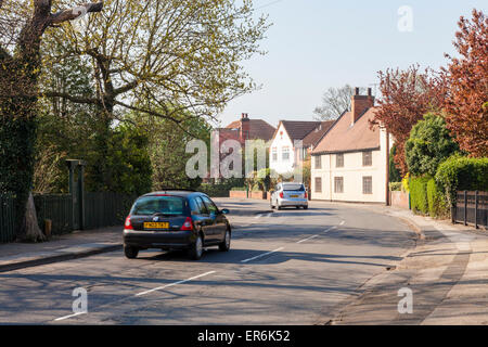 Voitures voyageant dans une rue de village Wilford, Nottingham, England, UK Banque D'Images