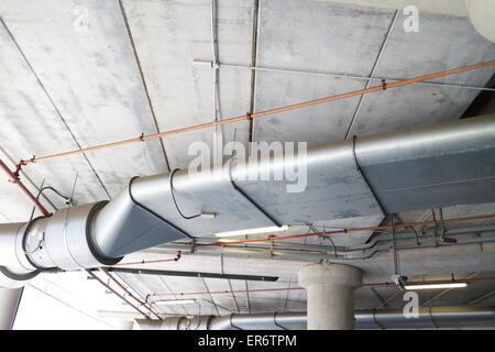 Parc souterrain d'un centre commercial avec des colonnes et des conduits de ventilation Banque D'Images