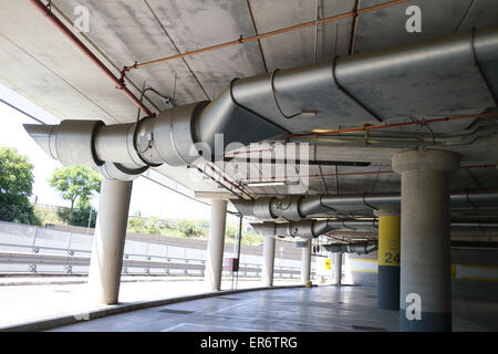 Parc souterrain d'un centre commercial avec des colonnes et des conduits de ventilation Banque D'Images