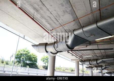 Parc souterrain d'un centre commercial avec des colonnes et des conduits de ventilation Banque D'Images