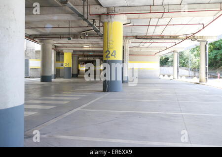 Parc souterrain d'un centre commercial avec des colonnes et des conduits de ventilation Banque D'Images