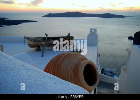 L'urne grecque et le vieux bateau sur un toit blanc dans la ville de Fira, Santorini, Grèce, avec la caldeira derrière. Banque D'Images