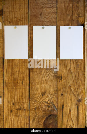 Feuilles de papier blanc fixé sur la paroi en bois avec les punaises Banque D'Images