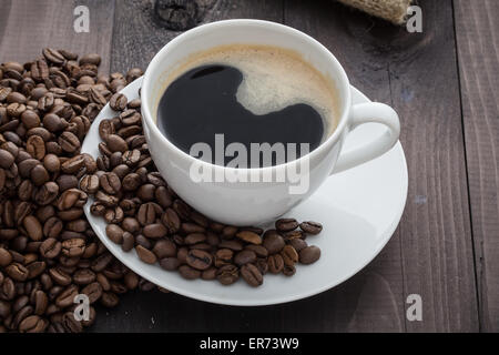 Tasse de café blanc avec café et autour de la tasse de café se trouve Banque D'Images