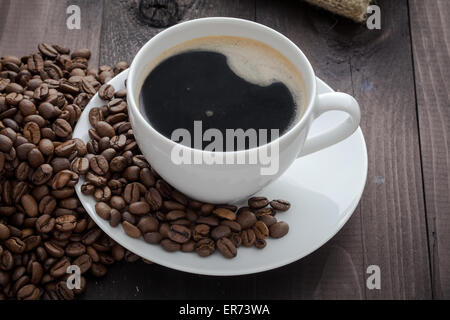 Tasse de café blanc avec café et autour de la tasse de café se trouve Banque D'Images