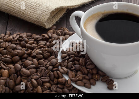 Tasse de café blanc avec café et autour de la tasse de café se trouve Banque D'Images