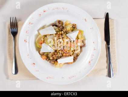 Portrait de plat préparé servi dans un bol blanc à Place avec fourchette et couteau Banque D'Images