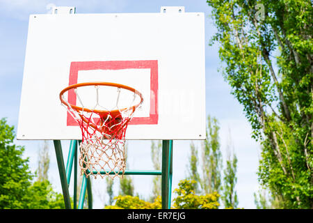 Low Angle View of panier de basket-ball, Basket et retour Conseil sur une cour entourée d'arbres Banque D'Images