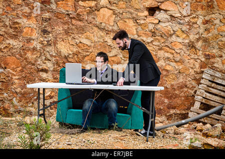 Deux gars autour d'un bureau dans un bureau grunge, un concept de faillite Banque D'Images