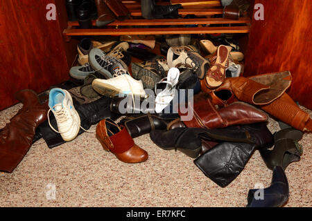 Sélection de womens shoes untidily éparpillés sur le sol à l'avant de l'armoire dans la chambre Banque D'Images