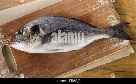 Poisson cru frais sur une planche à découper en bois. Banque D'Images