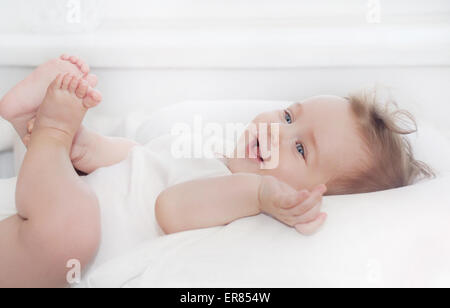 Cute little happy baby boy lying on soft white pillow, concept de famille heureuse Banque D'Images