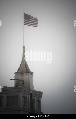 Drapeau américain au-dessus du bâtiment contre le ciel clair Banque D'Images