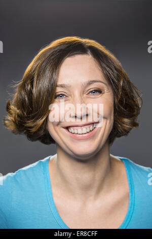 Portrait of happy Mid adult woman sur fond gris Banque D'Images