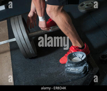 La section basse de l'homme avec barbell in gym Banque D'Images