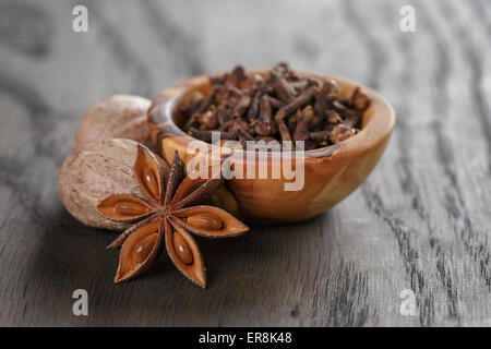 Les étoiles d'anis et de girofle Muscade dans bol d'olive sur la table en chêne, rustique Banque D'Images