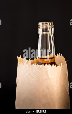 Détail de la bouteille dans le sac en papier sur le fond noir Banque D'Images