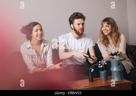 Heureux les jeunes amis à jouer à des jeux vidéo à la maison Banque D'Images
