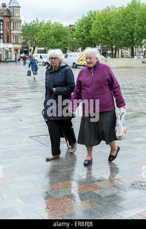 De vieilles dames une marche sous la pluie à Salisbury Banque D'Images