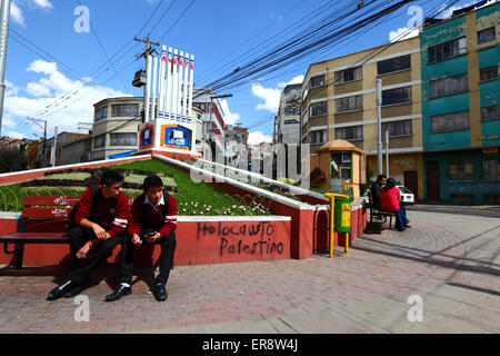 Les élèves s'asseoir sur un banc à côté d'un monument juif qui a été dégradé en protestation contre les actions israéliennes à Gaza, La Paz, Bolivie Banque D'Images