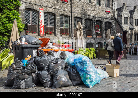 Les personnes qui s'y passé tas d'ordures et de sacs poubelles entassées avec blocage des ordures ménagères dans la ville de la chaussée Banque D'Images