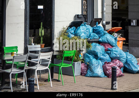 Des sacs poubelle et conteneurs à déchets entassés avec blocage des ordures ménagères en raison d'une grève de la chaussée par l'entreprise de traitement des déchets Banque D'Images