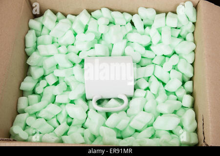 Mug à l'intérieur d'une boîte en carton. Banque D'Images