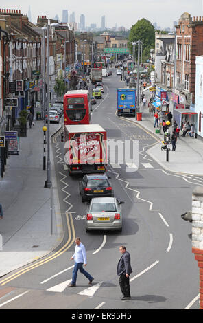 Les piétons traversent Lee Bridge Road, une banlieue animée high street, dans le nord de Londres montre voitures, camions, autobus et la congestion du trafic Banque D'Images