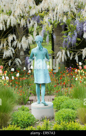 Statue de jeune fille appelée la 'lampe de la sagesse'. Statue jardin ornemental et de glycine dans le jardin formel d'archway à Waterperry Jardins, Oxfordshire, UK Banque D'Images