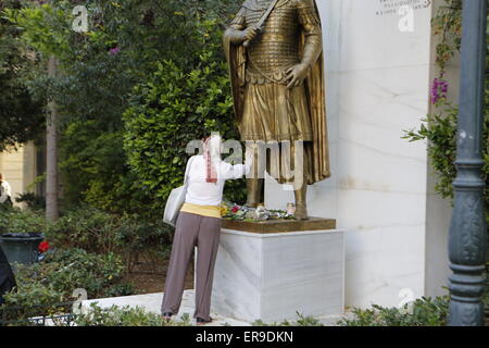 Athènes, Grèce. 29 mai 2015.Une femme touche la jambe de la statue du dernier empereur byzantin Constantin XI Paléologue après avoir jeté des fleurs à ses pieds. Parti de droite Aube dorée a tenu un rassemblement à Athènes, se souvenant de la chute de Constantinople et la mort du dernier empereur byzantin Constantin XI Paléologue en 1453. Son état de légende qu'il va reconquérir Constantinople pour le christianisme. Crédit : Michael Debets/Alamy Live News Banque D'Images