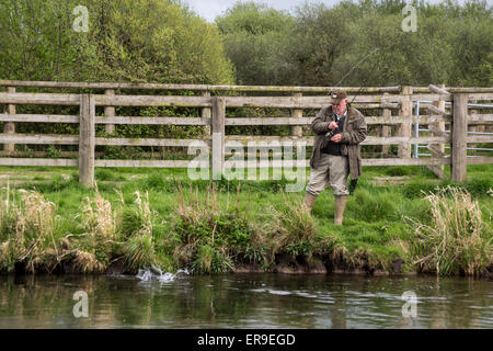 Pêcheur attraper la truite, rivière Test à Leckford, Hampshire, England, UK. Banque D'Images