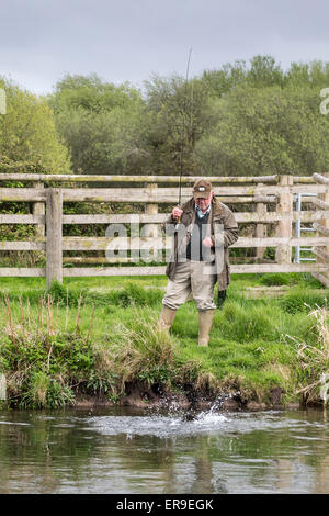 Pêcheur attraper la truite, rivière Test à Leckford, Hampshire, England, UK. Banque D'Images