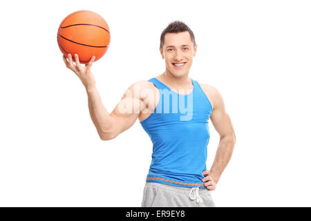 Beau Jeune homme posant avec un terrain de basket-ball dans sa main isolé sur fond blanc Banque D'Images