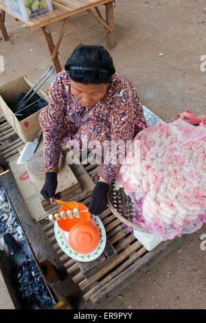 Une femme vend du vendeur bananes frites ambulante à Kampong Cham, au Cambodge. Banque D'Images