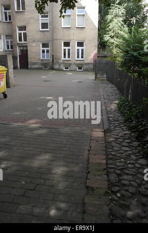 Les fondations en brique rouge de passage du mur du Ghetto de Varsovie cour avec le jaune aller au bloc d'appartement, Rue Zlota 62, Varsovie, Pologne Banque D'Images