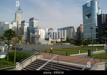 Tamar dh Park HONG KONG ADMIRALTY Man jogging in Park et Wanchai gratte-ciel asie jogger Banque D'Images