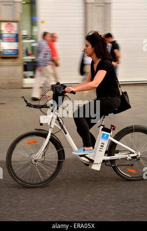 Woman riding a partagé public embauché BiciMad vélo électrique à Madrid, Espagne Banque D'Images