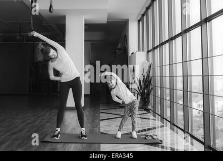Deux jeunes filles de différents âges makeing yoga Banque D'Images