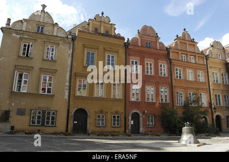 Ciel bleu voir cloche de bronze debout devant des maisons colorées ornées historique tenement, Canon Square, Vieille Ville, Varsovie, Pologne Banque D'Images