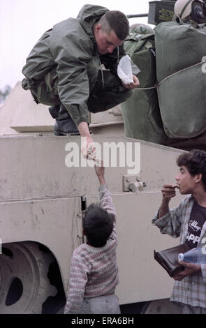 23 mars 1991 un soldat de l'armée américaine donne des bonbons aux enfants irakiens dans un camp près de Safwan dans le sud de l'Irak, près de la frontière avec le Koweït.