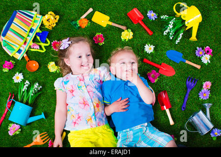 Jardinage pour les enfants. Les enfants avec les outils de jardin. Enfant avec arrosoir et pelle. Petit enfant arrosage des fleurs. Banque D'Images