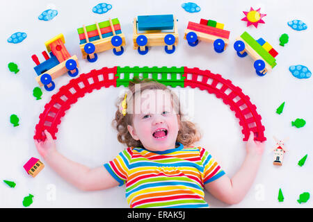 Enfant jouant avec un train. Fer jouet pour les enfants. Tout-petit enfant à la garderie. Jouets éducatifs pour l'école maternelle Banque D'Images