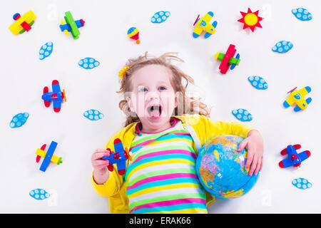 Enfant jouant avec des avions. Enfant d'âge préscolaire voler autour du monde. Les enfants qui voyagent et jouer. Les enfants à la garderie Banque D'Images