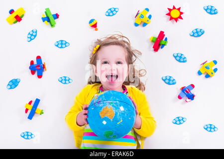 Enfant jouant avec des avions. Enfant d'âge préscolaire voler autour du monde. Les enfants qui voyagent et jouer. Banque D'Images