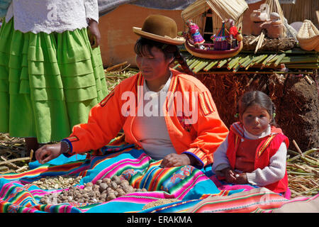 Les Indiens Uros femme et enfant avec des pommes de terre, Titino île flottante (Puno), lac Titicaca, Pérou Banque D'Images