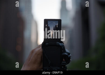 New York, USA. 30 mai, 2015. Un homme attend pour prendre des photos de "anhattanhenge» dans le Manhattan, New York, États-Unis, le 30 mai 2015. Les touristes, les habitants et les banlieusards attendu pour prendre des photos de l'effet "anhattanhenge» mais ont été contrecarrés par les nuages samedi. Le Manhattanhenge renvoie à la deux fois par année au cours de laquelle la circonstance coucher de soleil soit parfaitement aligné avec les rues est-ouest de New York. © Muzi Li/Xinhua/Alamy Live News Banque D'Images