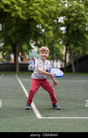 Petit garçon joue sur une journée ensoleillée de Frisbee Banque D'Images