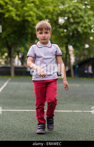 Petit garçon joue sur une journée ensoleillée de Frisbee Banque D'Images